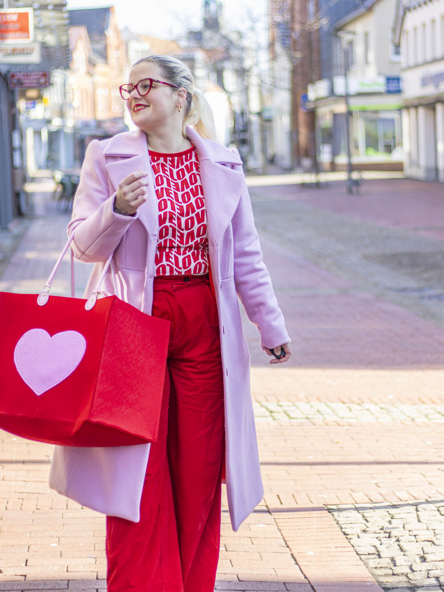 Bloggerin im rosa-roten Valentins-Outfit zeigt den selbstgenähten Filzkorb Corazon mit Herz-Tasche aus Filz.