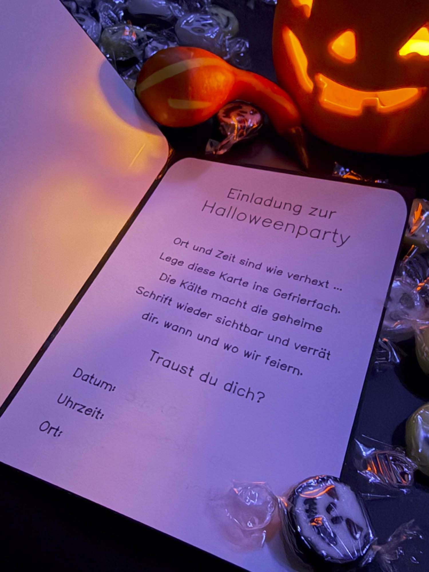 Aufgeklappte Halloweenkarte mit Sketch-&-Cut-Einladungstext und Hinweis, die geheime Schrift durch Kälte im Gefrierfach sichtbar zu machen.