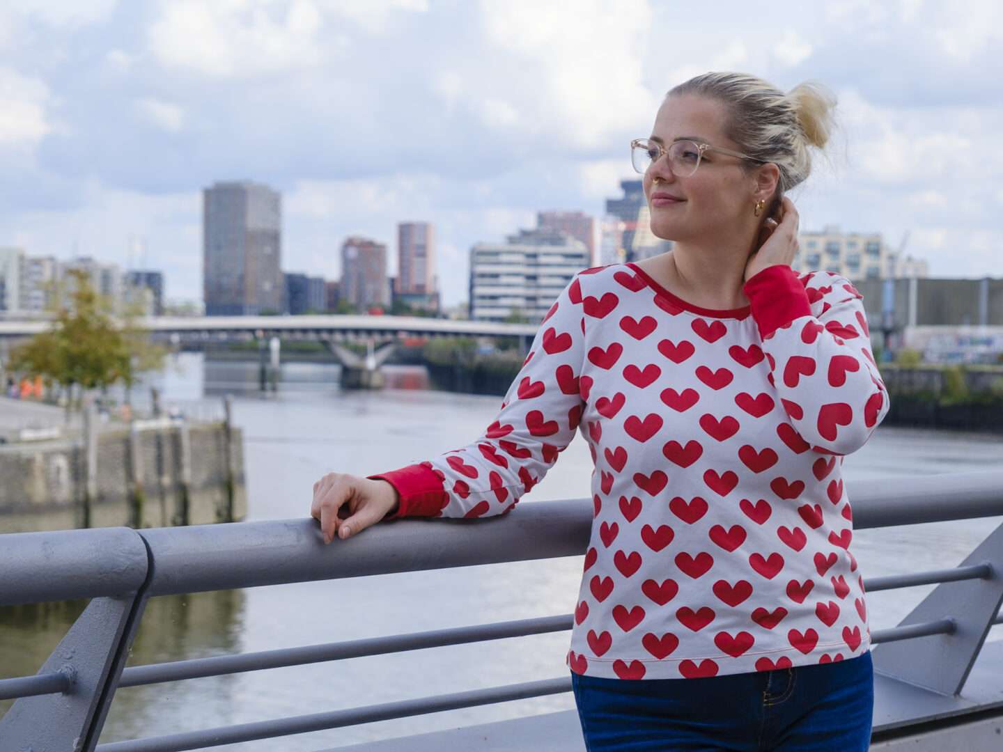 Lisa trägt Frau Nikki aus gemustertem Baumwolljersey mit roten Herzen mit roten Hals- und Ärmelbündchen – Vorderansicht.